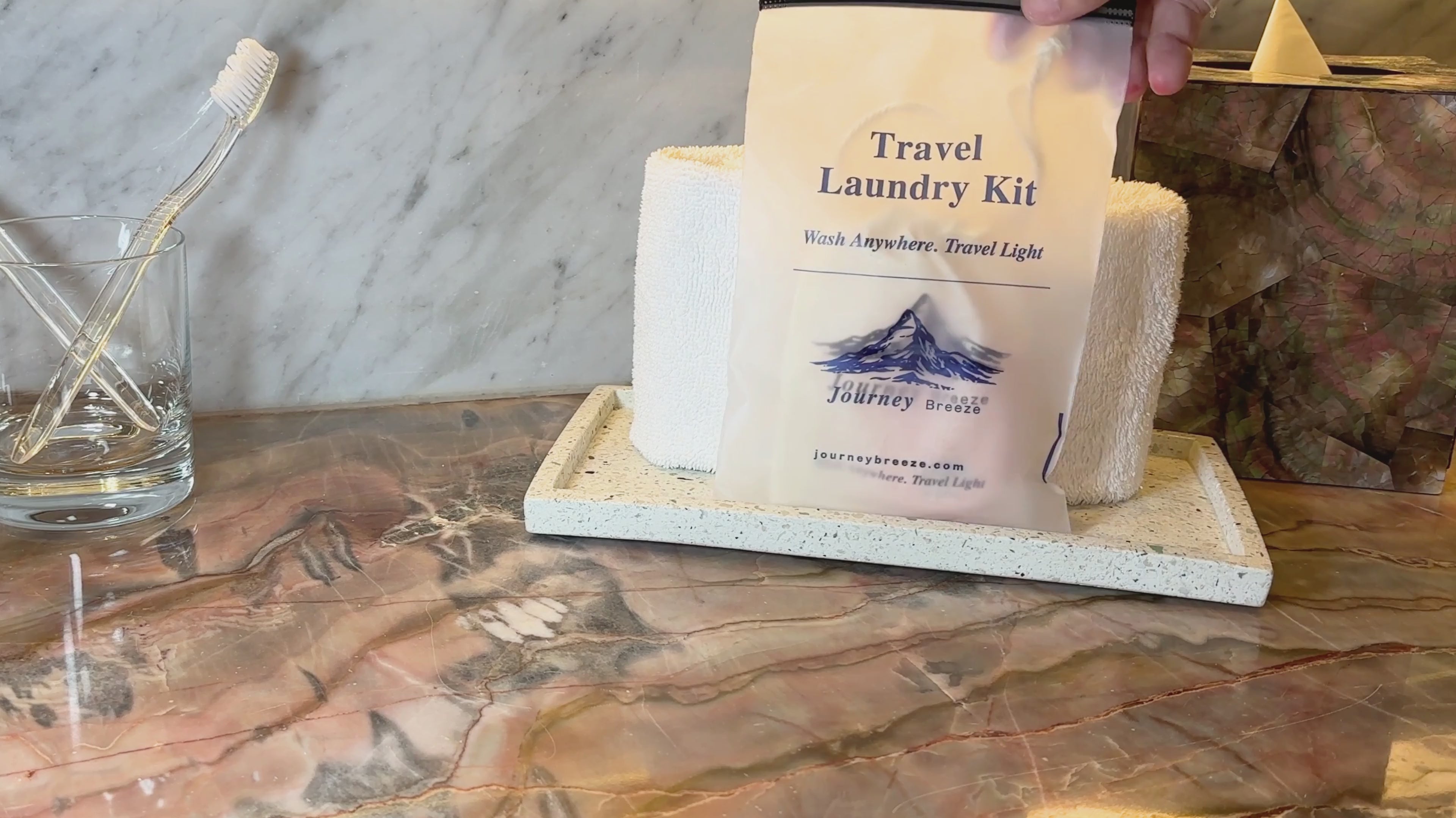 Load video: Orange Journey Breeze laundry sheets shown as a compact, eco-friendly travel detergent.
